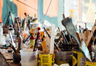 messy table full of paint brushes